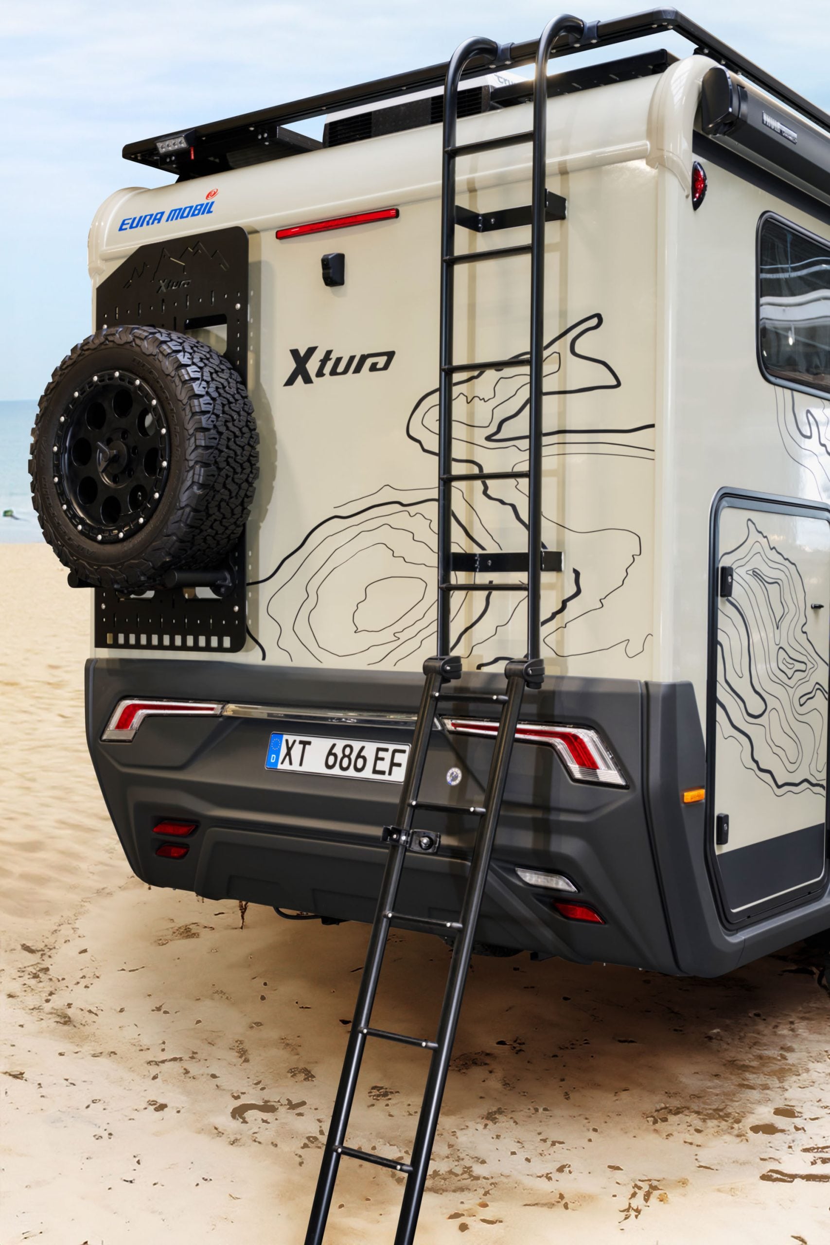 Vue arrière du Xtura avec roue de secours et échelle sur le toit.