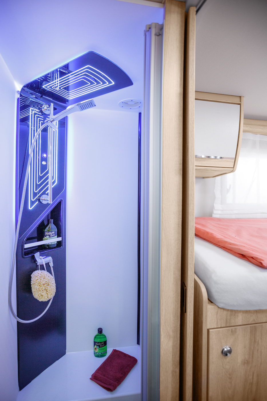 À gauche, on voit une douche, à droite, vue sur l'espace de couchage.