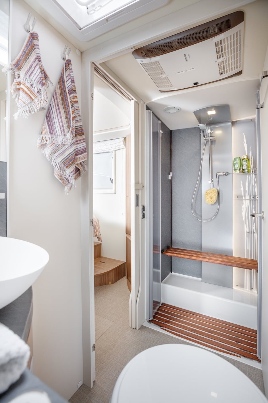 Salle de bain dans un camping-car avec vue sur la douche.