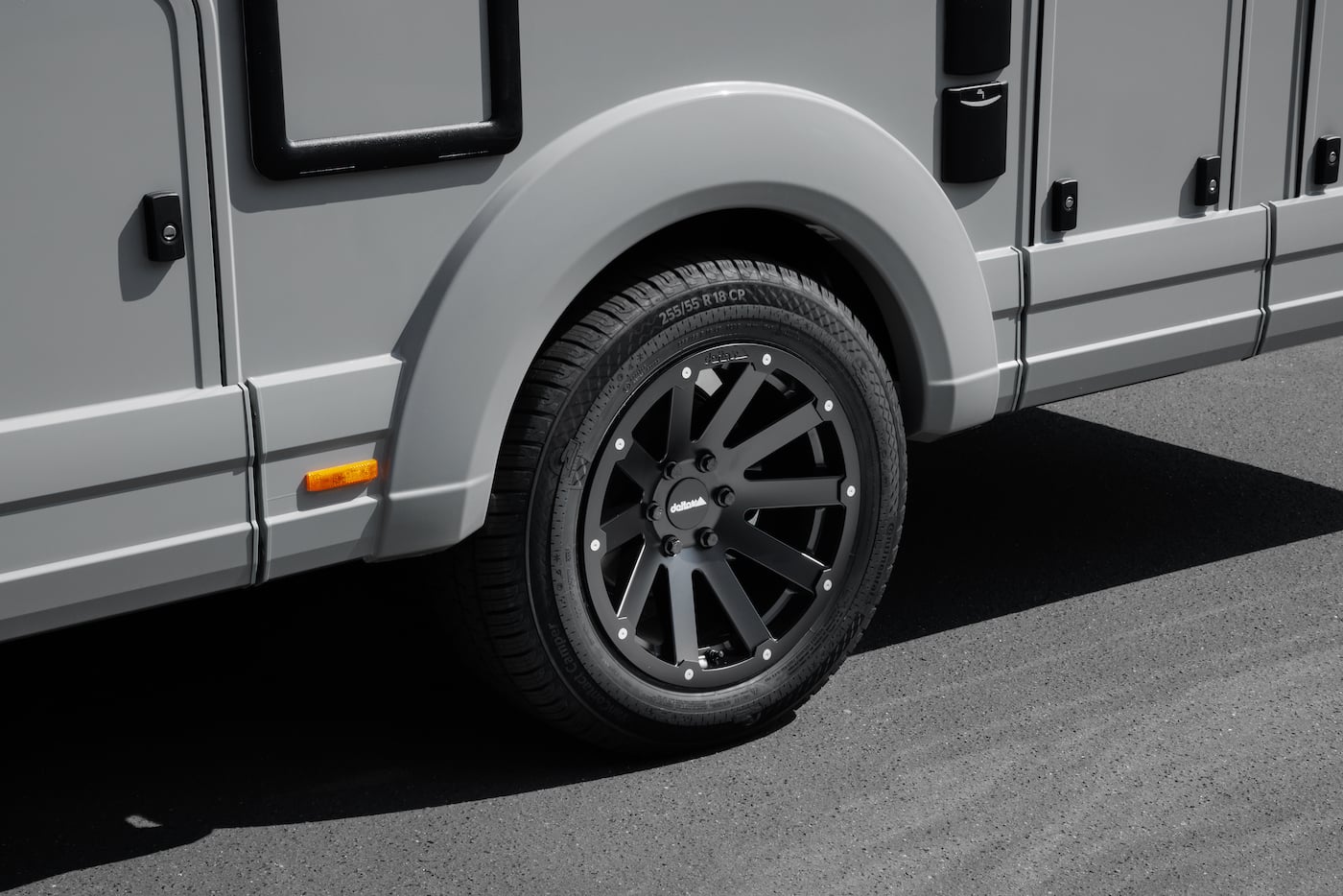 Roue arrière d'un camping-car en gros plan, debout sur la route.