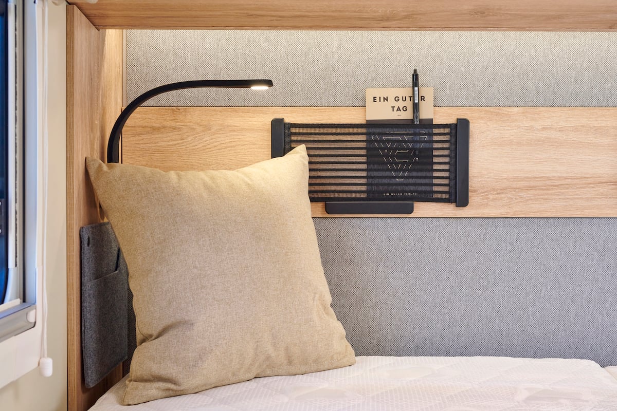 Coin salon avec coussins et lampe à col de cygne.